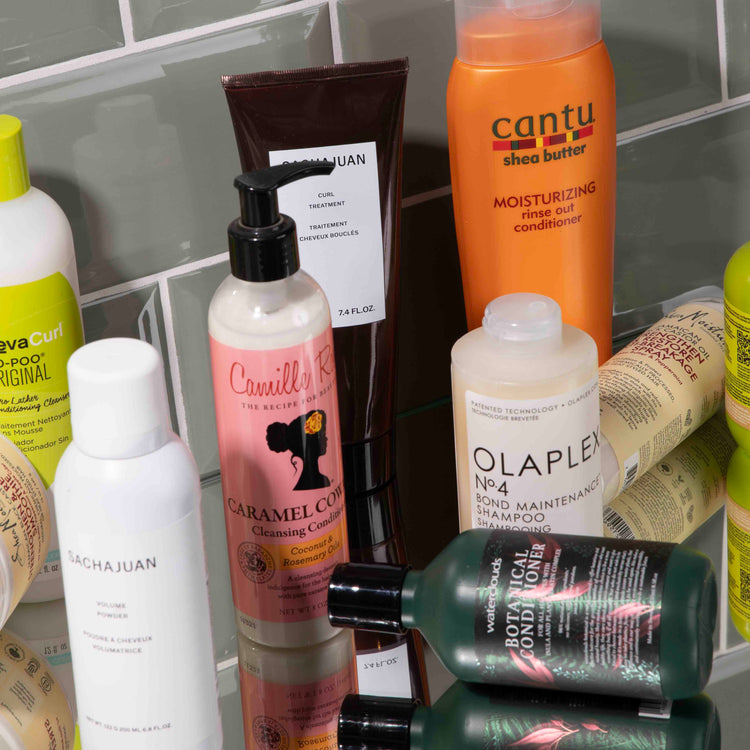 Cantu Shea Butter Rinse Out Conditioner in een oranje fles, verrijkt met pure sheaboter voor diepe hydratatie en versterking van droog of beschadigd haar.